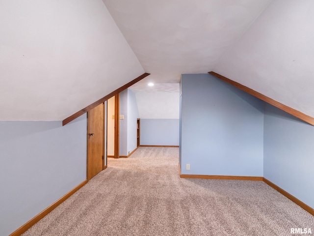 bonus room featuring vaulted ceiling and light colored carpet