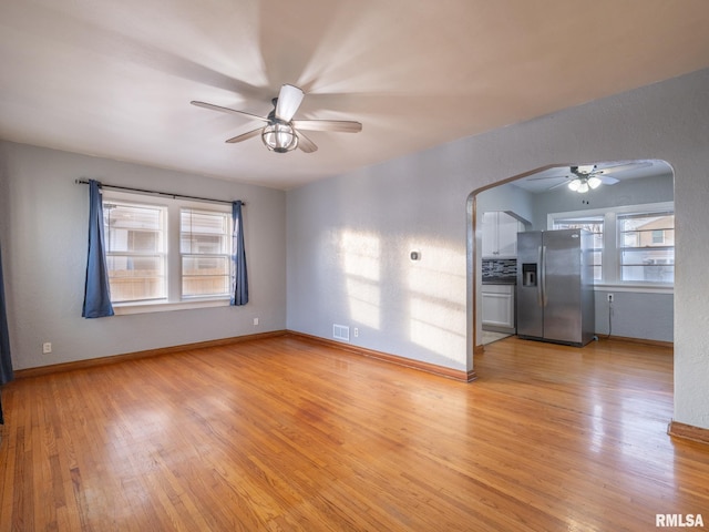 unfurnished living room featuring ceiling fan and light wood-type flooring