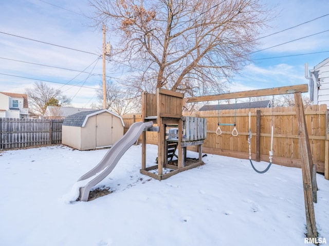 snow covered playground featuring a shed