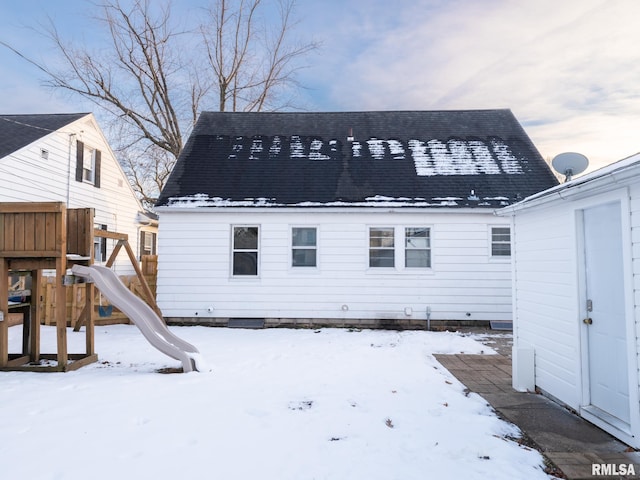 snow covered property with a playground