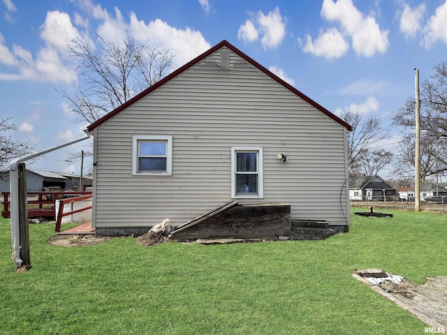 view of side of home featuring a lawn and a wooden deck