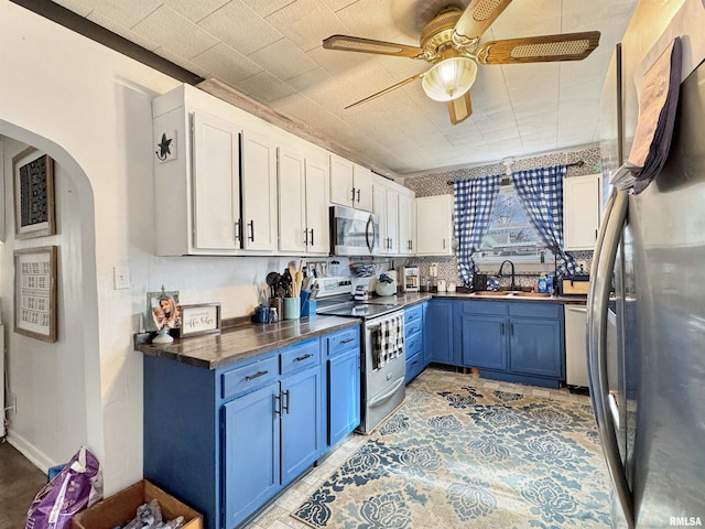 kitchen featuring blue cabinetry, white cabinetry, appliances with stainless steel finishes, and butcher block countertops