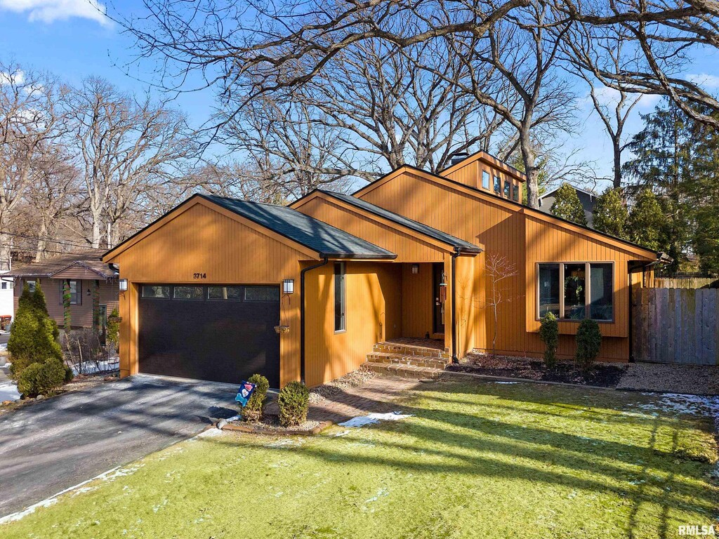 view of front of house with a garage and a front lawn