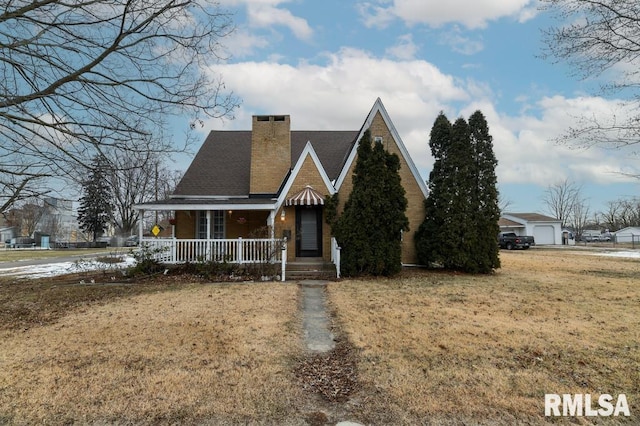 view of front of house featuring covered porch, a garage, and a front lawn