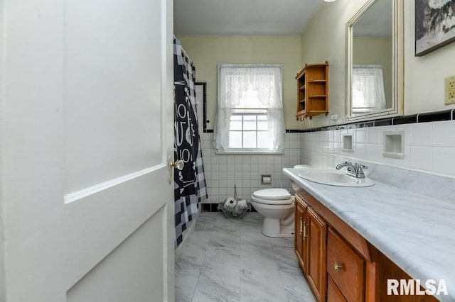 bathroom with toilet, tile walls, and vanity