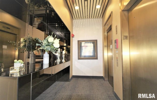 hall with dark tile patterned flooring and elevator