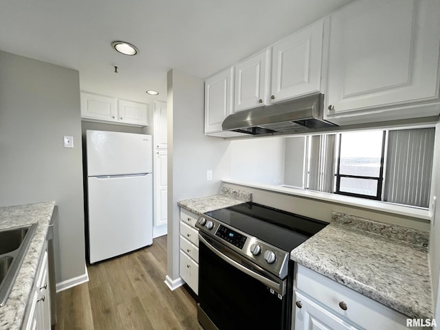 kitchen featuring light stone countertops, white cabinetry, white fridge, light hardwood / wood-style floors, and electric range