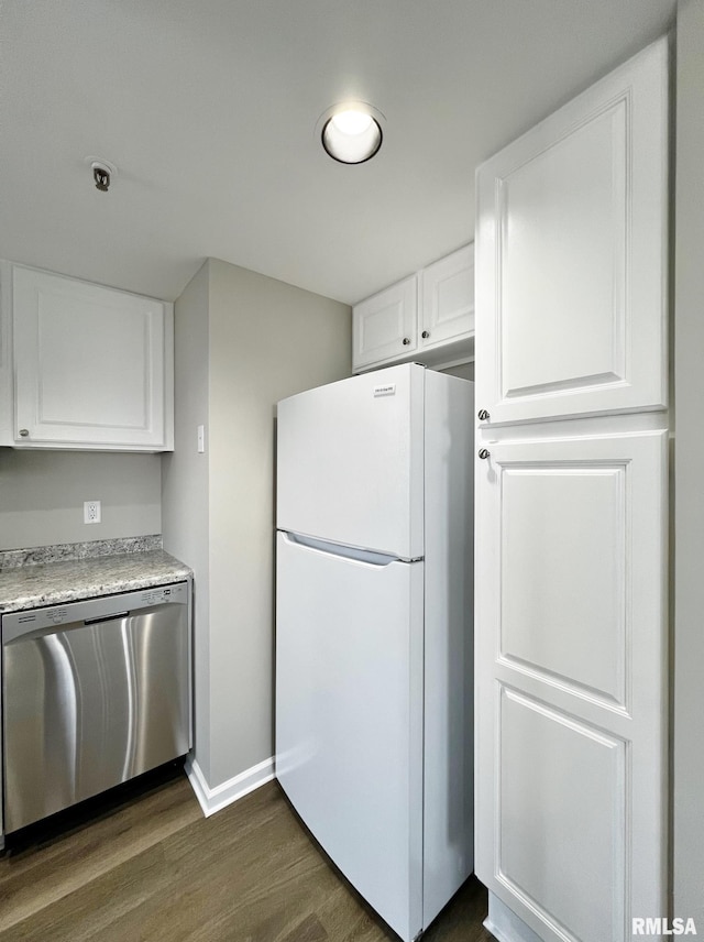 kitchen featuring white cabinets, dark wood-type flooring, white fridge, and stainless steel dishwasher