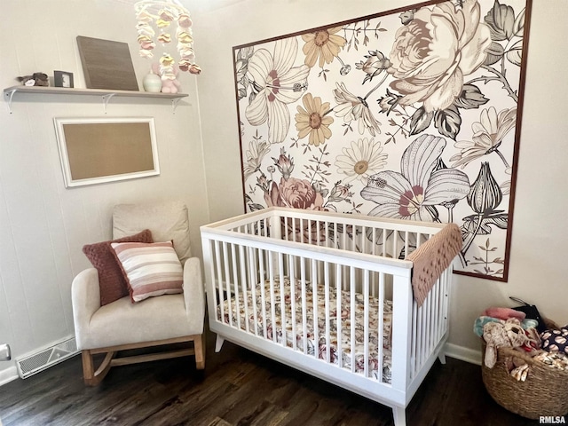 bedroom featuring hardwood / wood-style floors and a nursery area