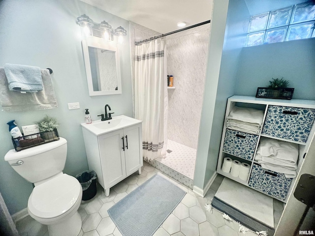 bathroom featuring toilet, walk in shower, tile patterned floors, and vanity