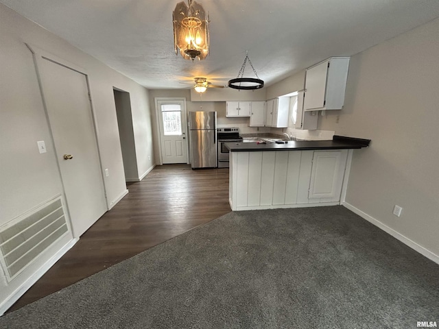 kitchen with dark carpet, white cabinetry, appliances with stainless steel finishes, and kitchen peninsula