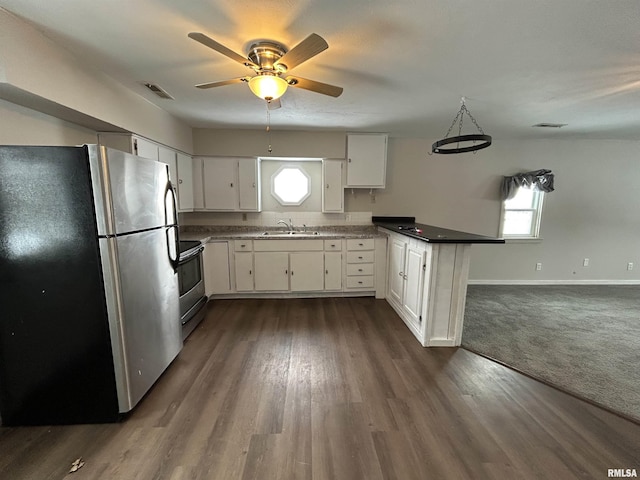 kitchen with white cabinets, stainless steel appliances, dark colored carpet, sink, and kitchen peninsula