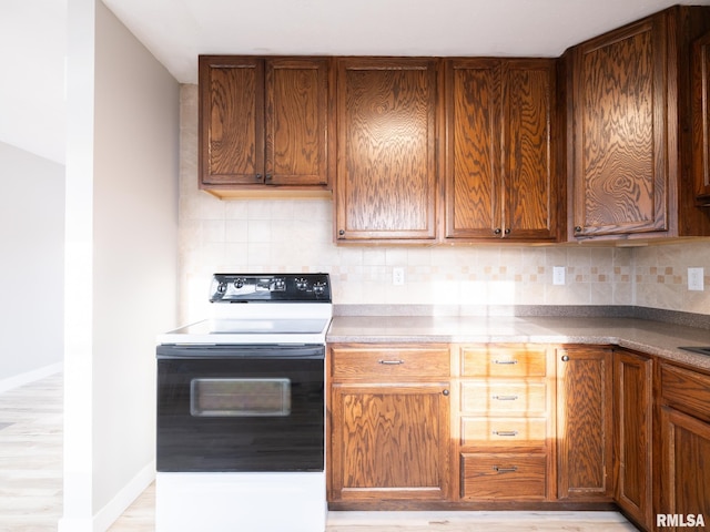 kitchen with range with electric cooktop, light hardwood / wood-style flooring, and tasteful backsplash