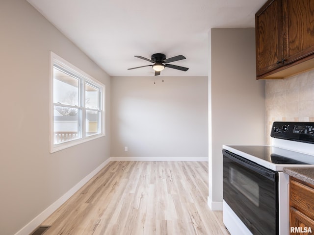 kitchen featuring ceiling fan, backsplash, light hardwood / wood-style floors, and electric stove