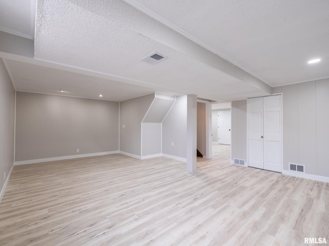 bonus room featuring light hardwood / wood-style floors and a textured ceiling