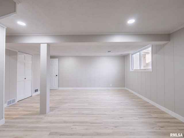 basement featuring light hardwood / wood-style flooring and ornamental molding