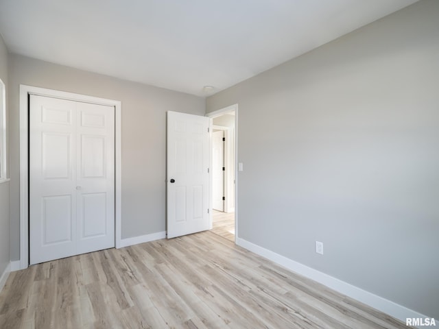 unfurnished bedroom with light hardwood / wood-style floors and a closet