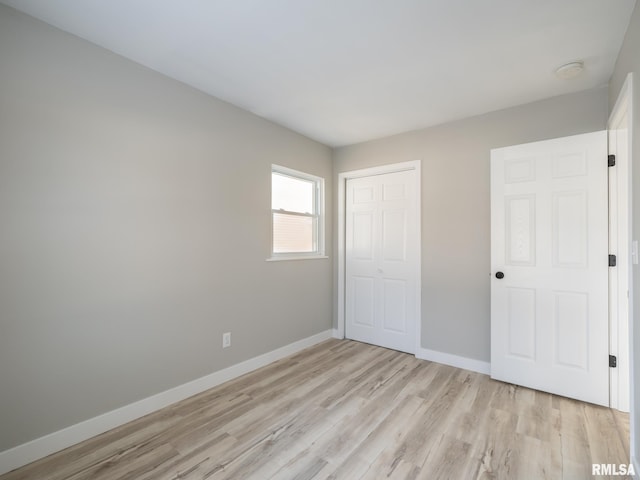 unfurnished bedroom with a closet and light hardwood / wood-style floors