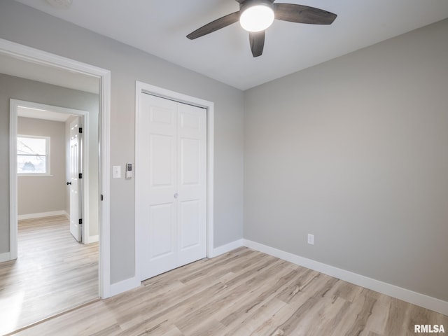 unfurnished bedroom with light hardwood / wood-style flooring, a closet, and ceiling fan