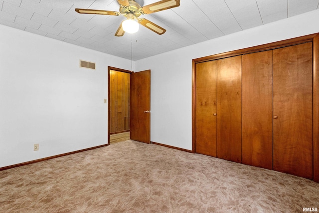 unfurnished bedroom with ceiling fan, light colored carpet, and a closet