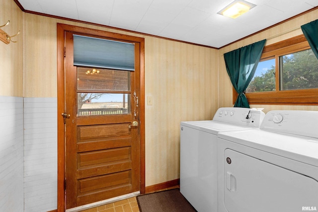 laundry room featuring ornamental molding, wooden walls, and washer and clothes dryer