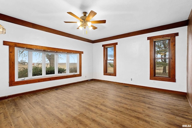 empty room with hardwood / wood-style flooring, ceiling fan, and a healthy amount of sunlight