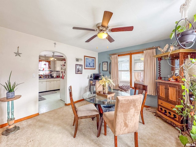 carpeted dining area with ceiling fan