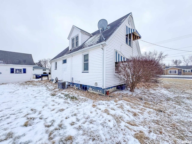 snow covered property featuring central AC