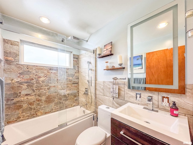 full bathroom with toilet, vanity, shower / bath combination with glass door, and tile walls