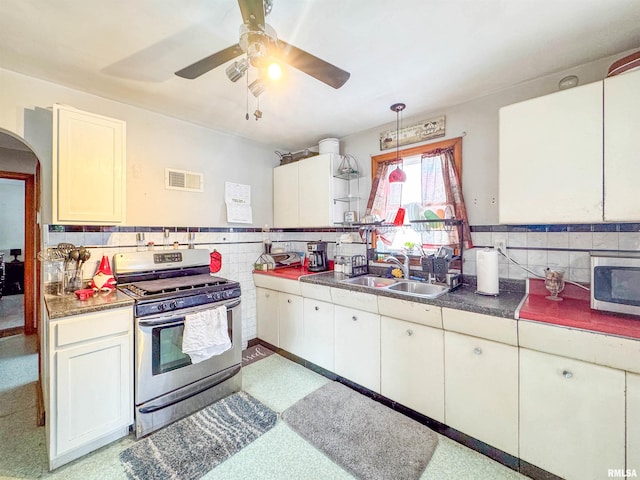 kitchen with sink, ceiling fan, white cabinetry, stainless steel appliances, and decorative light fixtures