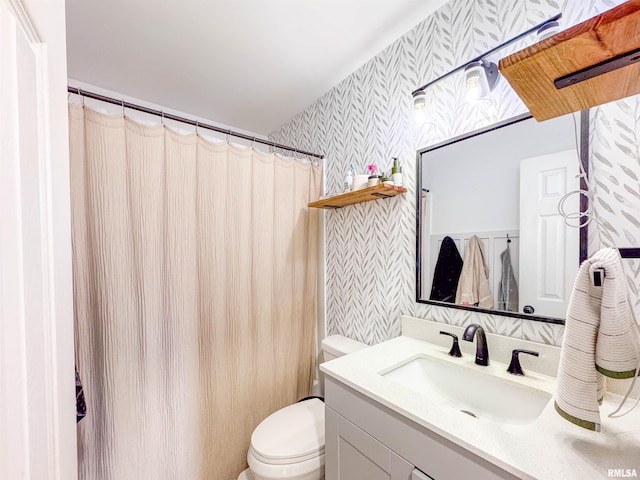 bathroom with vanity, toilet, and walk in shower