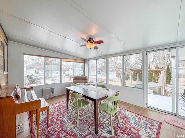 sunroom / solarium featuring ceiling fan, lofted ceiling, and a wall unit AC