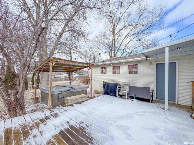 snow covered deck with a hot tub