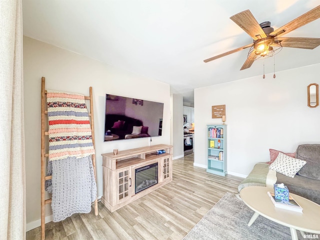 living room with light hardwood / wood-style floors and ceiling fan