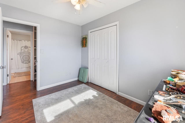 unfurnished bedroom with dark hardwood / wood-style flooring, a closet, and ceiling fan