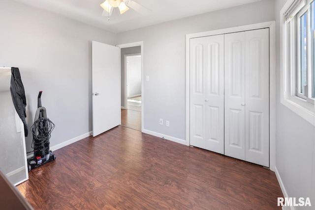 unfurnished bedroom with dark hardwood / wood-style flooring, ceiling fan, and a closet