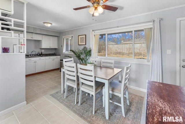 tiled dining area with ornamental molding, sink, and ceiling fan