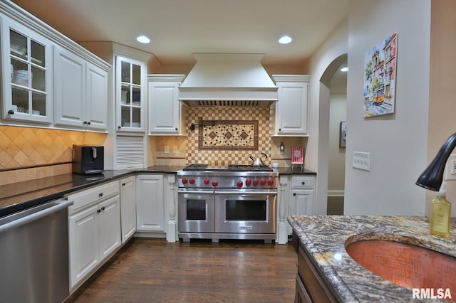 kitchen featuring appliances with stainless steel finishes, white cabinetry, sink, dark wood-type flooring, and custom range hood