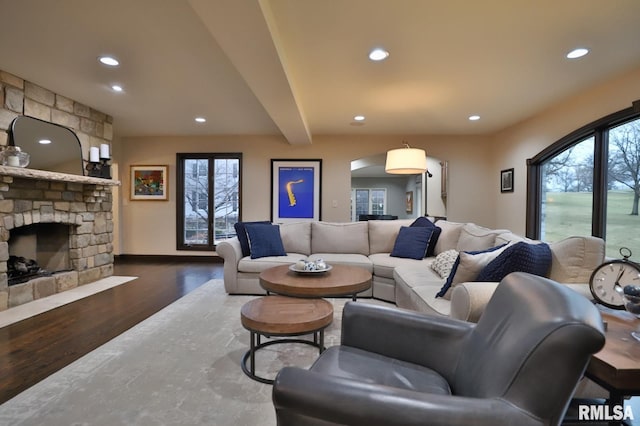 living room with beamed ceiling, dark wood-type flooring, and a fireplace