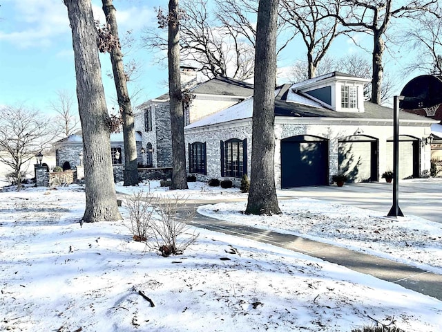 view of snowy exterior with a garage