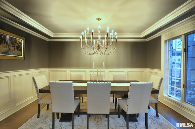 dining room featuring hardwood / wood-style flooring, crown molding, and a notable chandelier