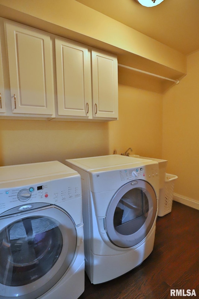 laundry area with dark wood-type flooring, cabinets, and washer and dryer