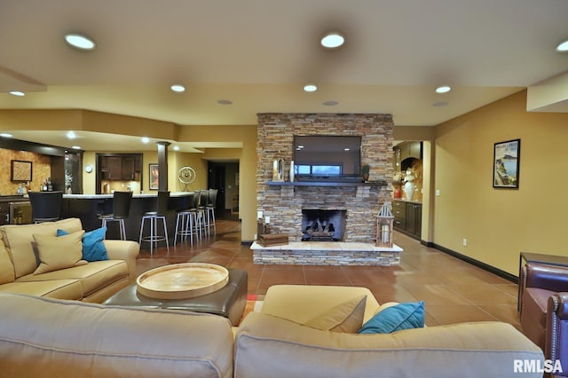 tiled living room with bar area and a fireplace