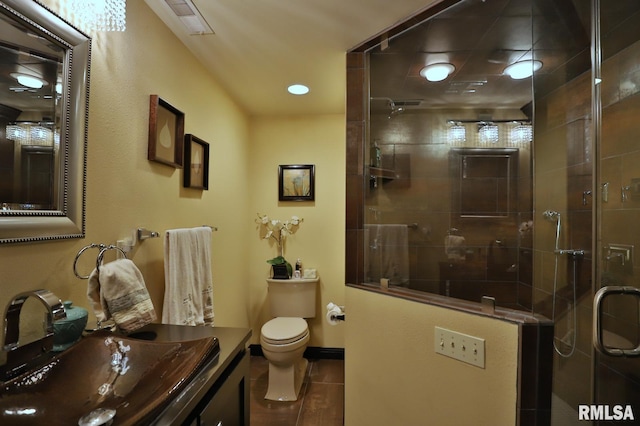 bathroom with vanity, toilet, a shower with shower door, and tile patterned flooring