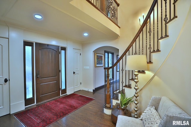 entrance foyer with dark hardwood / wood-style flooring and a towering ceiling