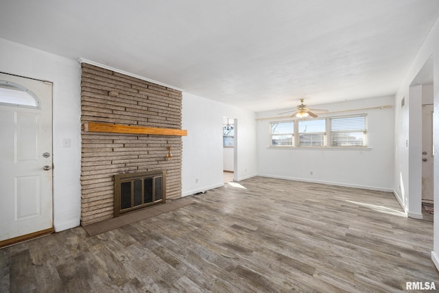 unfurnished living room with ceiling fan, wood-type flooring, and a fireplace