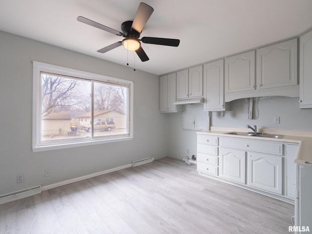 kitchen with ceiling fan, light hardwood / wood-style floors, sink, and white cabinets