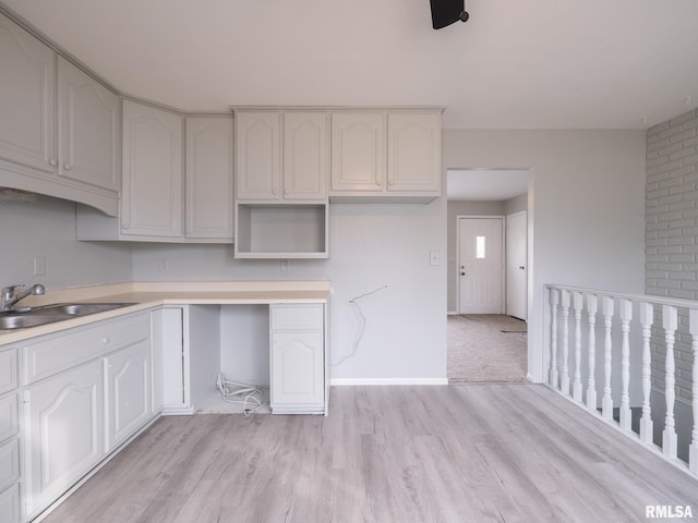 kitchen featuring sink, light hardwood / wood-style floors, and white cabinets