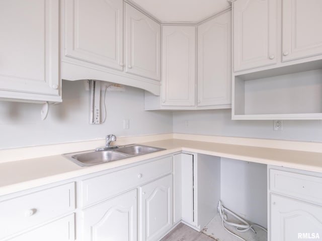 kitchen with sink, built in desk, and white cabinets