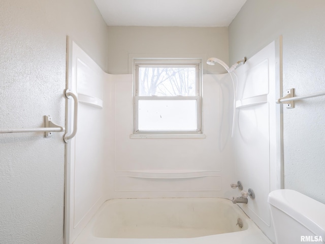 bathroom with bathing tub / shower combination and toilet